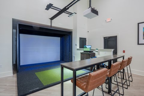 A conference room with a large screen and brown chairs.