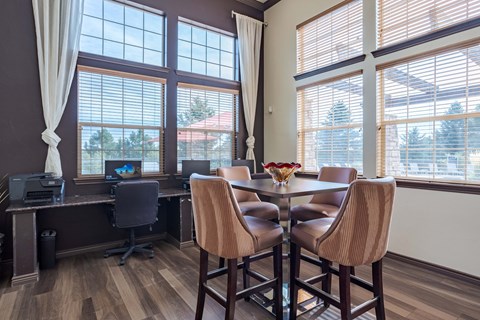 a dining room with a table and chairs and large windows