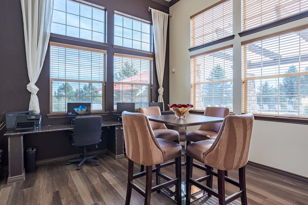 a dining room with a table and chairs and large windows