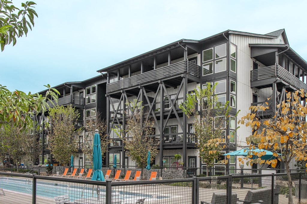 a building with a pool and a fence in front of it