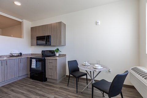 A kitchen with a table and chairs.