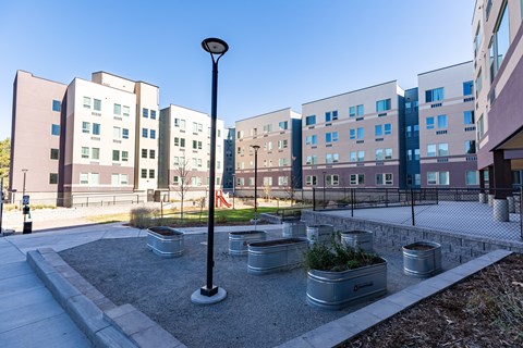 A modern building complex with a courtyard and planters.