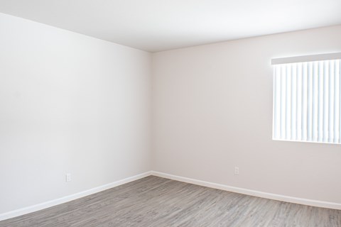 Empty bedroom with a window on the wall.