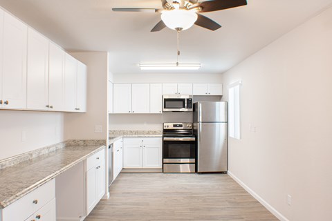 A kitchen with a fan hanging from the ceiling.