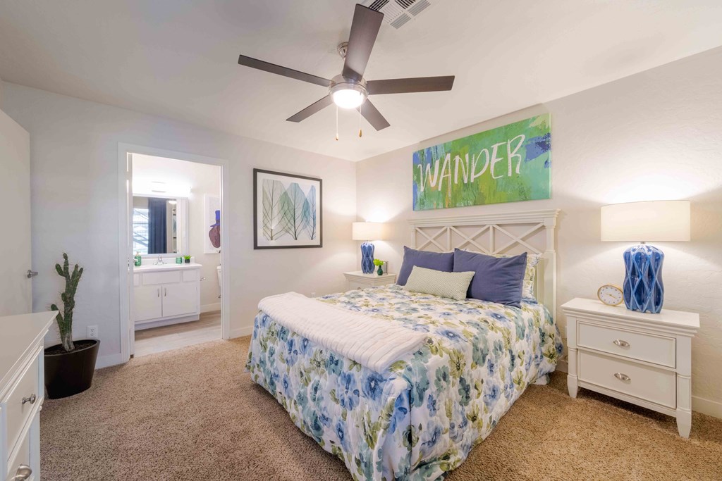 A bedroom with a bed, nightstand, and a ceiling fan.