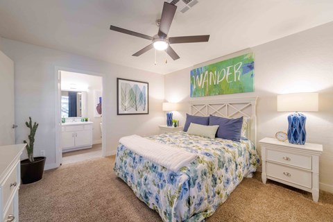 A bedroom with a bed, nightstand, and a ceiling fan.