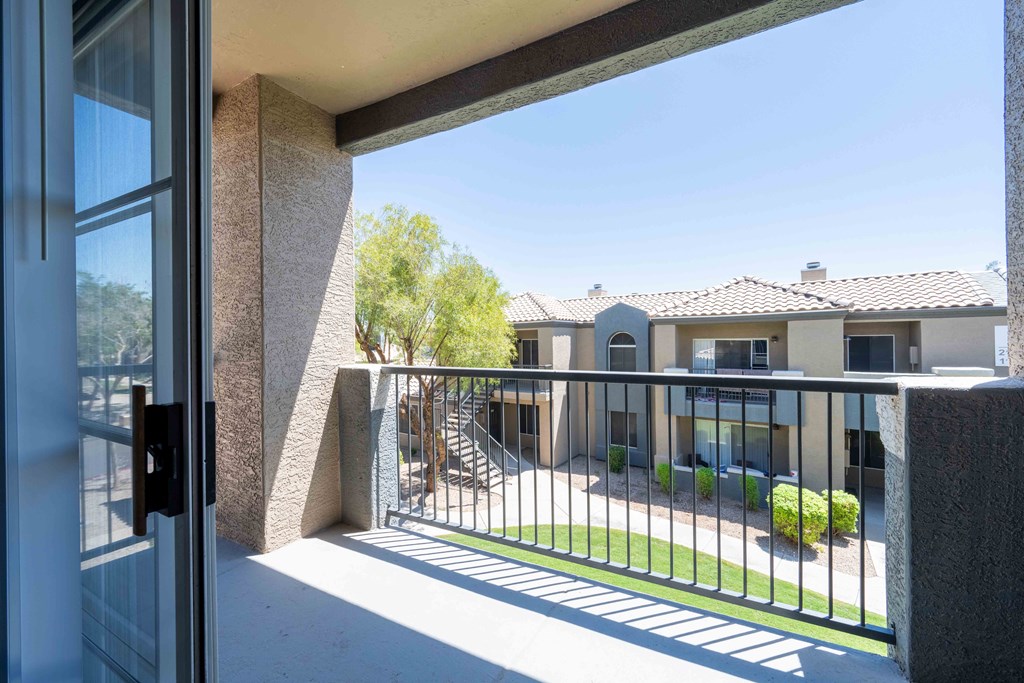 A view from a doorway looking out to a courtyard with a building in the background.