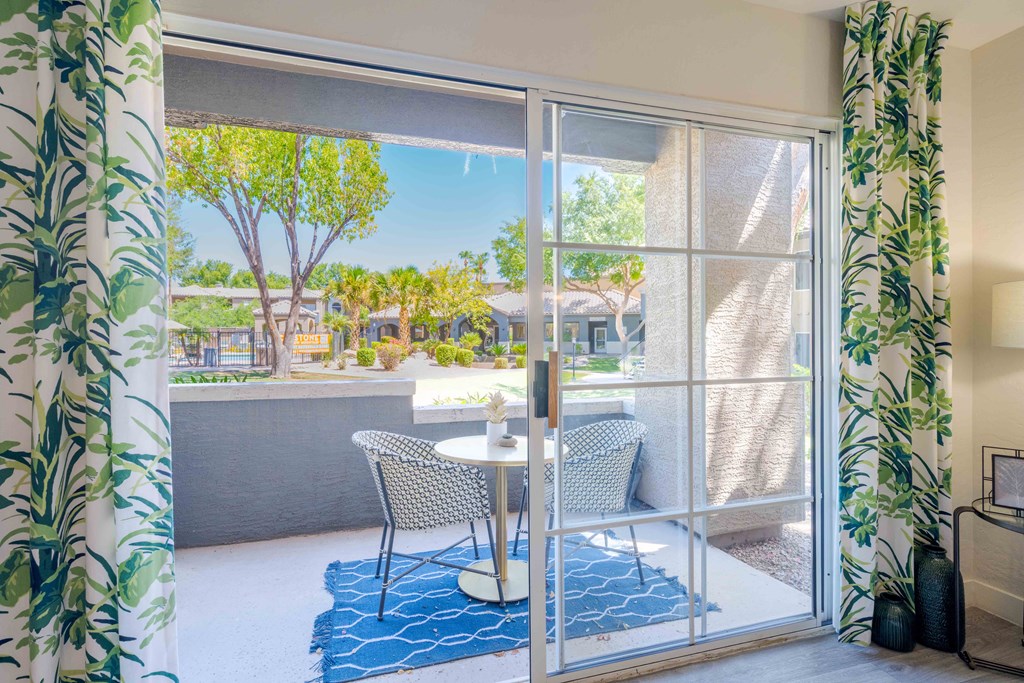 A patio with a table and chairs is visible through a sliding glass door.