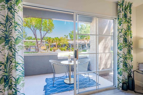 A patio with a table and chairs is visible through a sliding glass door.