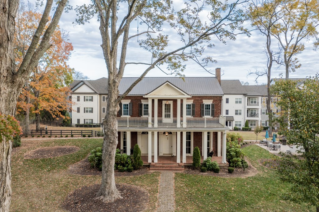 historic house with a yard and trees in front of it