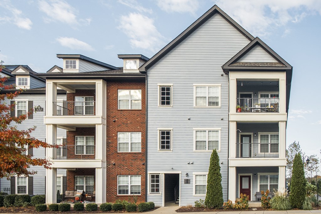 an apartment building with brick and white siding