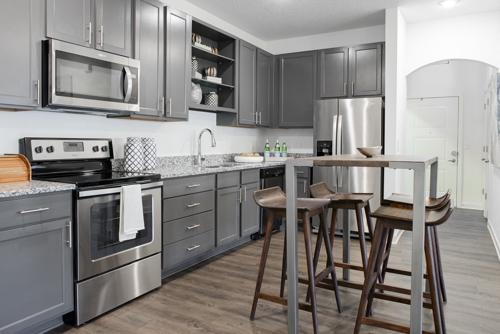 a kitchen with stainless steel appliances and a bar with stools
