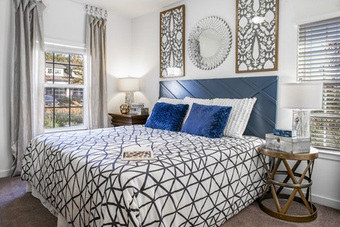 a bedroom with a bed and two windows