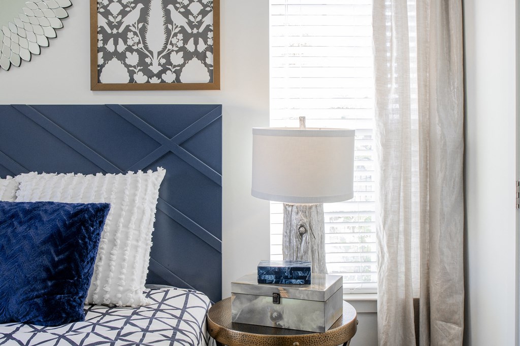 a bedroom with a bed and a lamp and a window