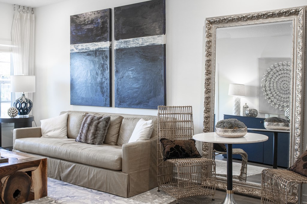 a living room with a couch and a table and two paintings on the wall