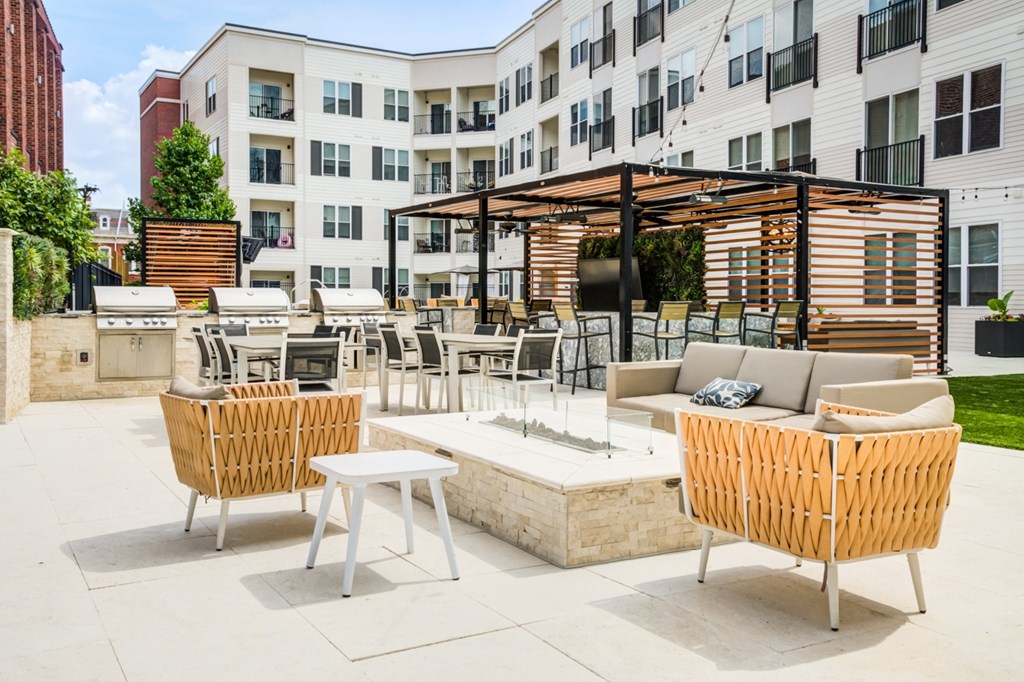 A patio area with a table, chairs and a sofa.