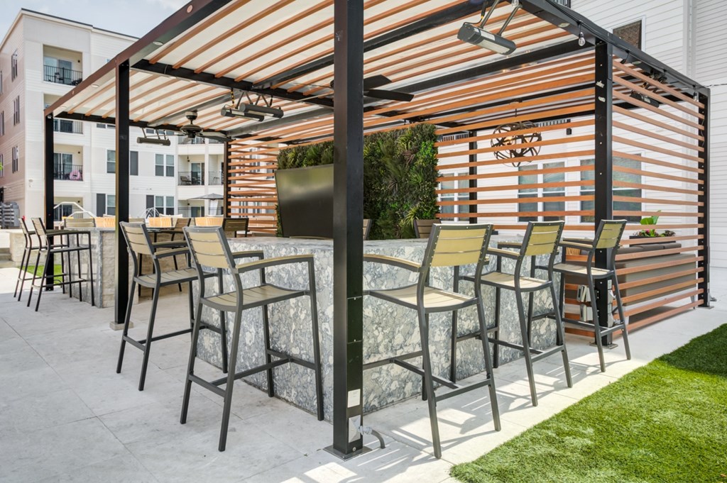 A patio with a table and chairs under a pergola.