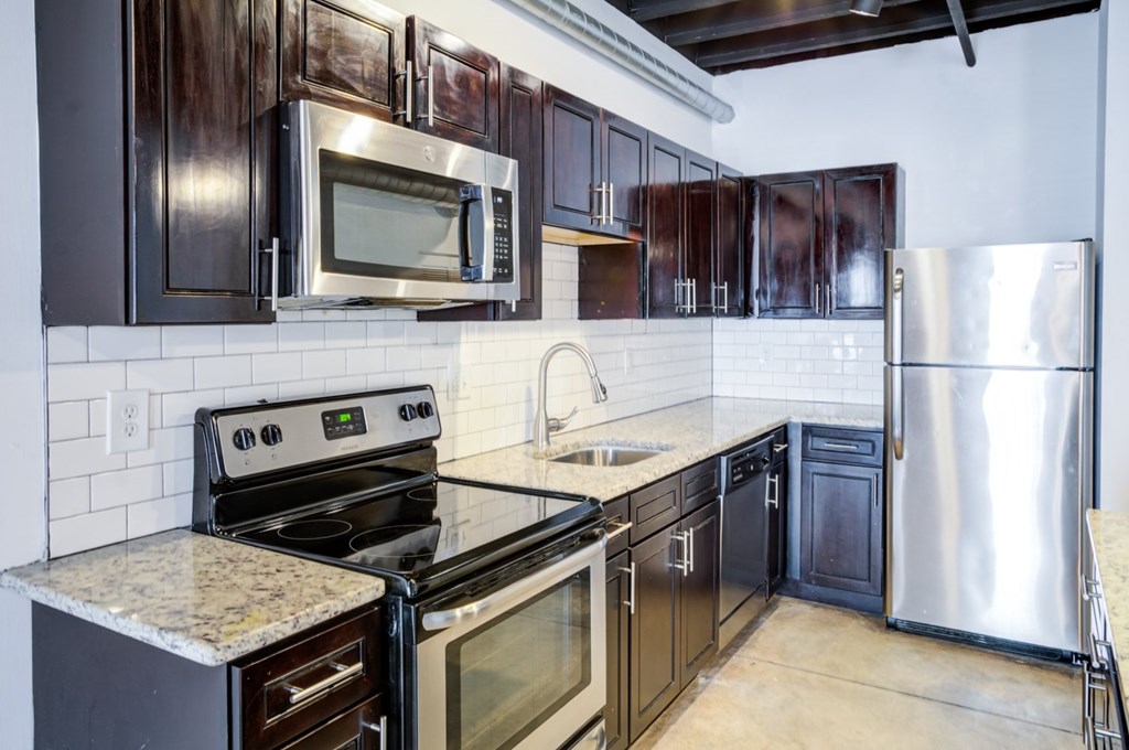 A kitchen with dark brown cabinets and stainless steel appliances.