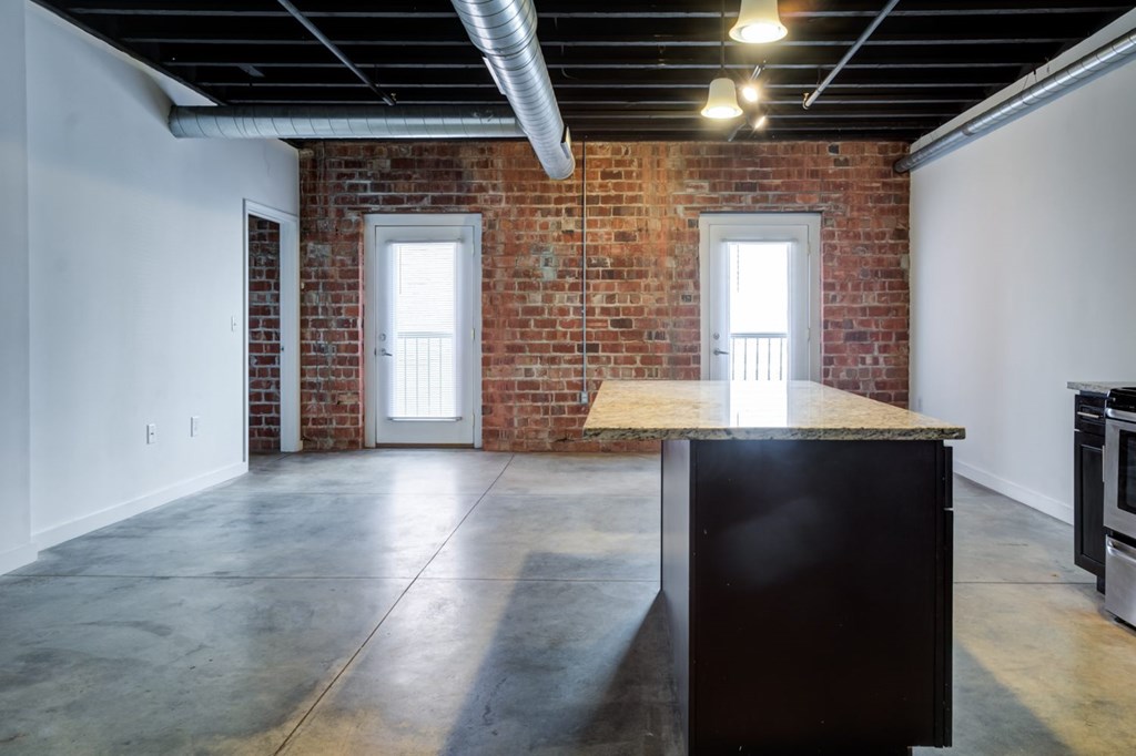 A room with a brick wall and a black cabinet.
