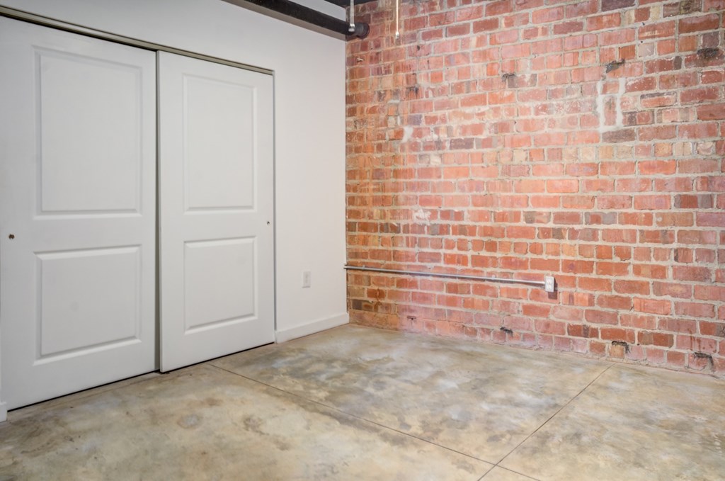 A room with a red brick wall and a white door.