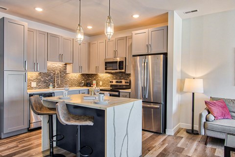 a kitchen with a center island and a stainless steel refrigerator