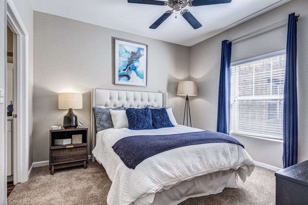 a bedroom with a bed and a ceiling fan