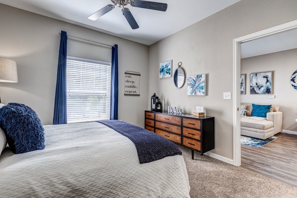 the master bedroom has a large window and a comfy bed