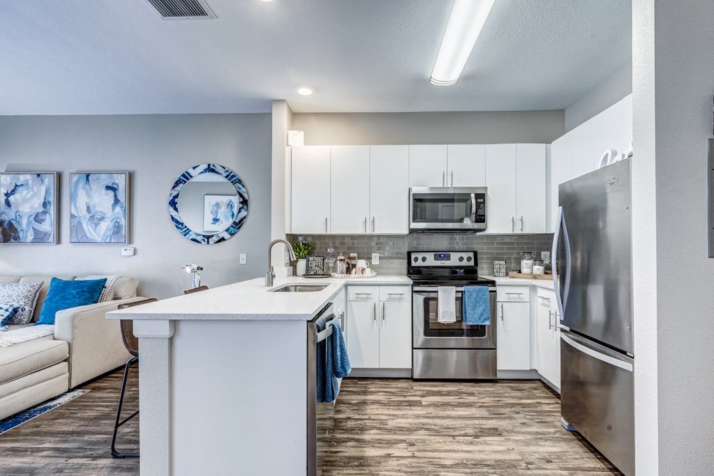 our spacious kitchen is equipped with stainless steel appliances and a white counter top
