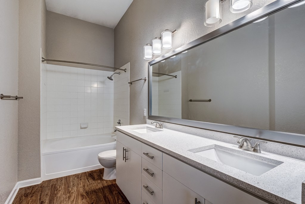 a bathroom with a large mirror and a toilet and a shower
