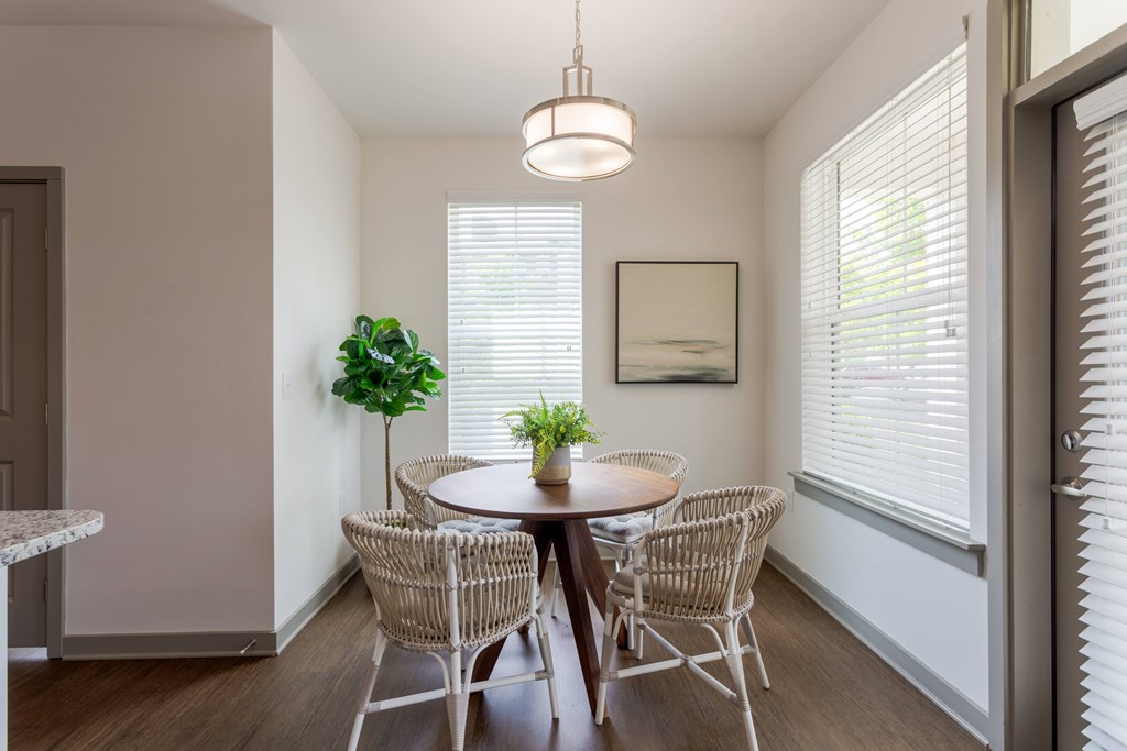 A dining room with a round table and chairs.