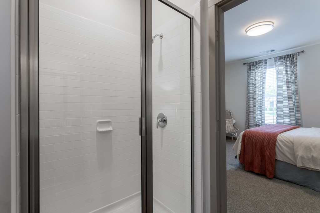 Bathroom with standing shower leading into a bedroom