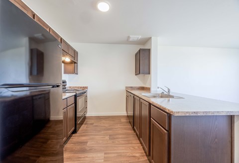 A kitchen with dark wood cabinets and a marble countertop.
