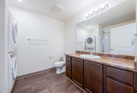 A bathroom with a toilet, sink, and mirror.