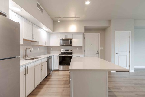 a kitchen with white cabinets and stainless steel appliances