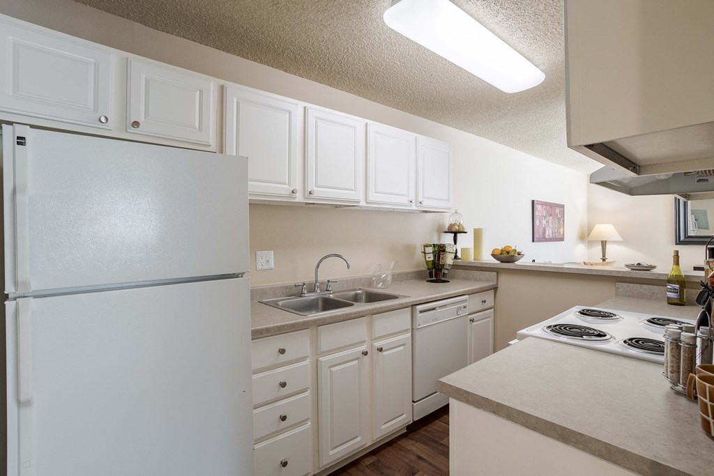 a kitchen with white cabinets and a sink and a refrigerator
