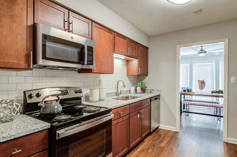a kitchen with wooden cabinets and a stove and a microwave