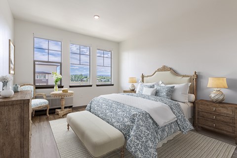 A bedroom with a large bed and a window overlooking a cityscape.