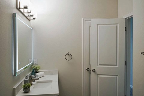 A bathroom with a white sink and a mirror above it.