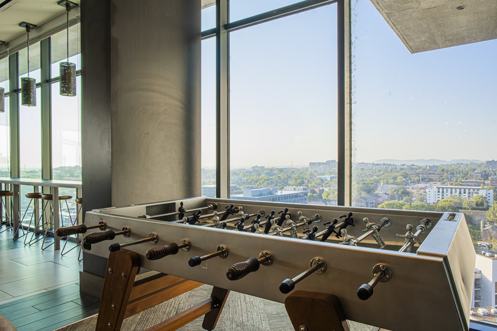 A foosball table in a room with a view of the city.