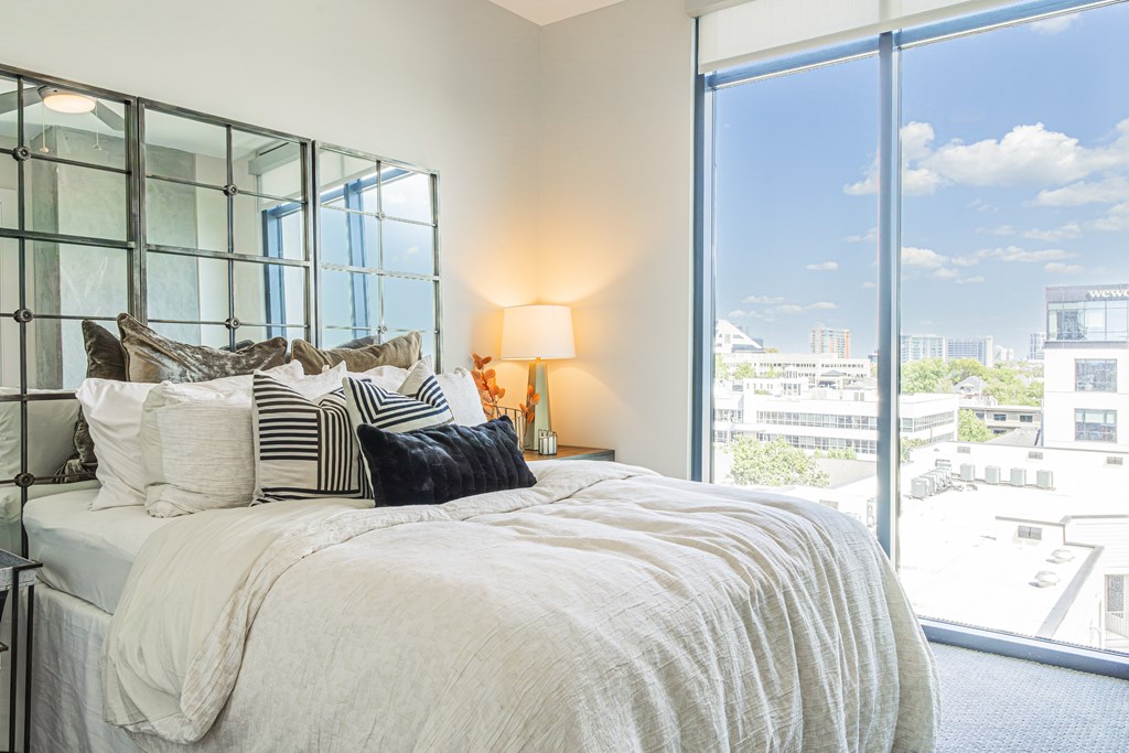 A bedroom with a large bed and a view of the city.
