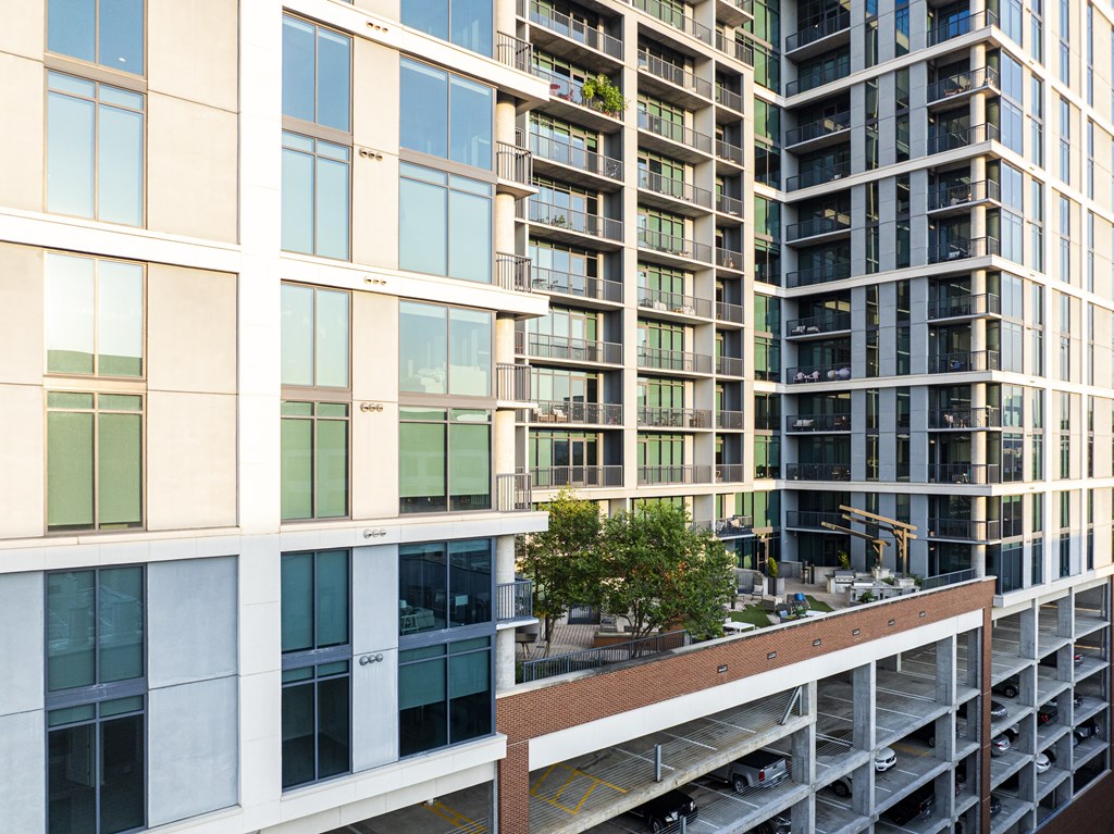 A modern building with a parking garage in front.