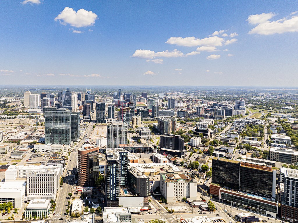 A cityscape with a mix of modern and older buildings under a clear sky.