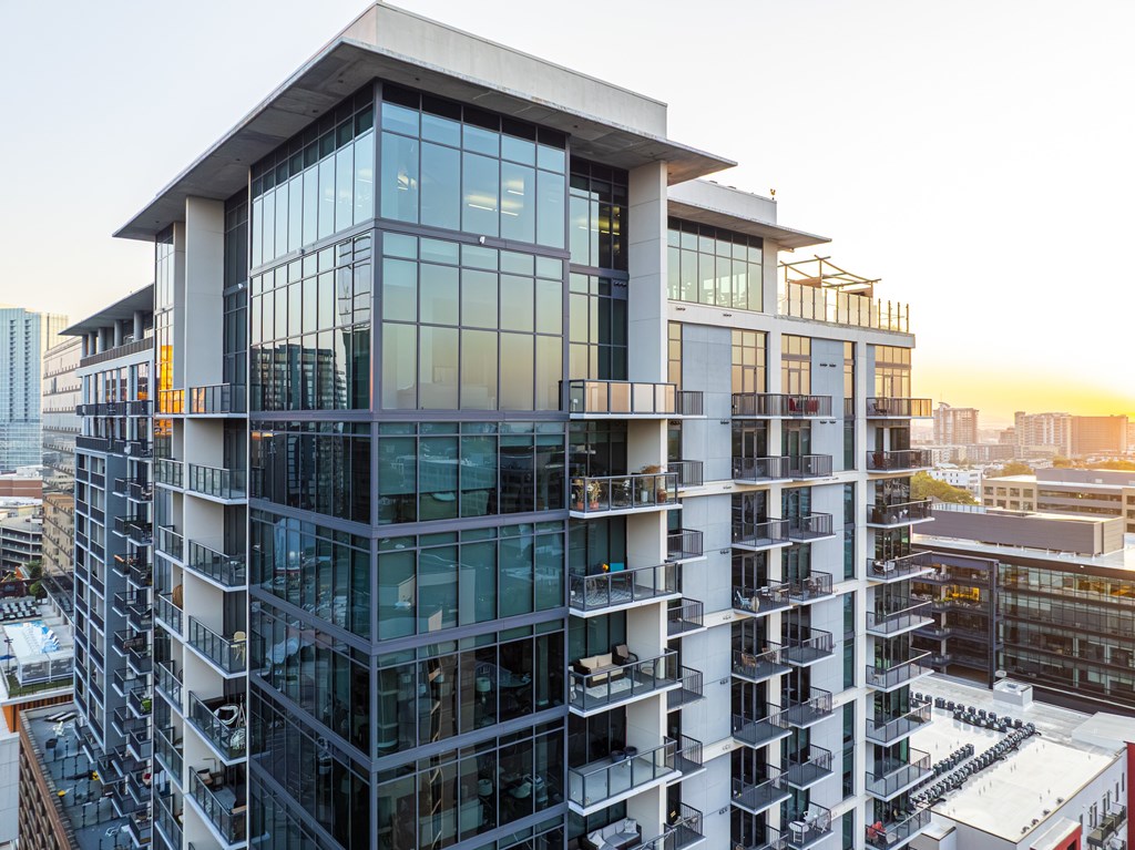 A modern multi-story building with balconies and large windows.