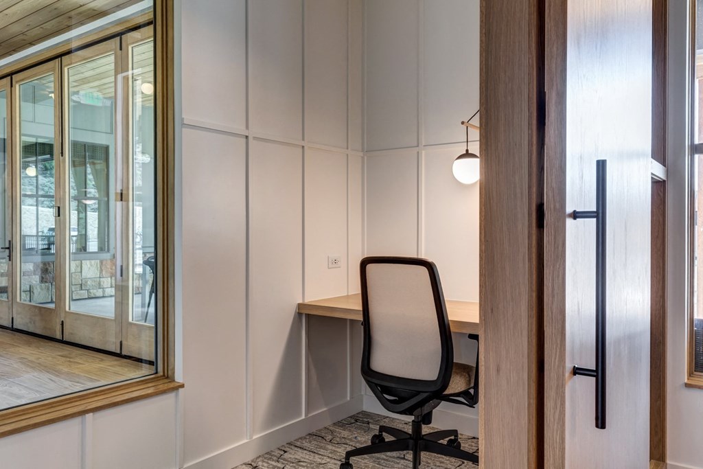 a desk with a chair in a room with a mirror