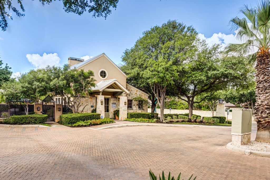 A house with a driveway and trees in front.