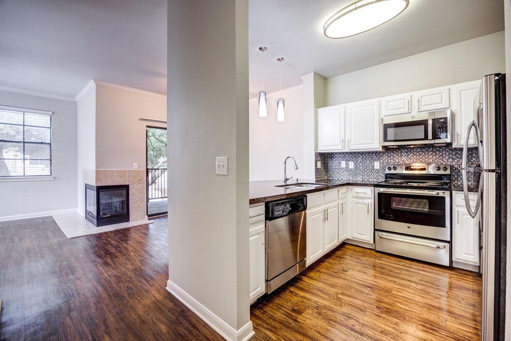 A kitchen with white cabinets and stainless steel appliances.