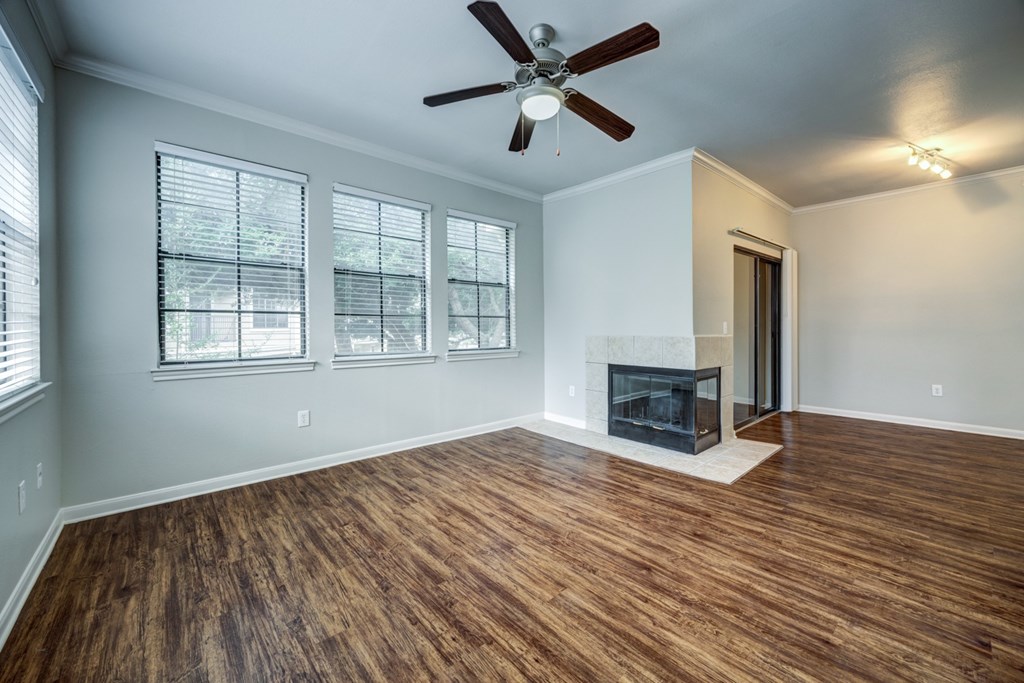 A room with a fireplace and a ceiling fan.