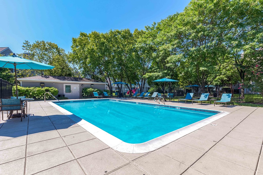 a swimming pool with chairs and umbrellas