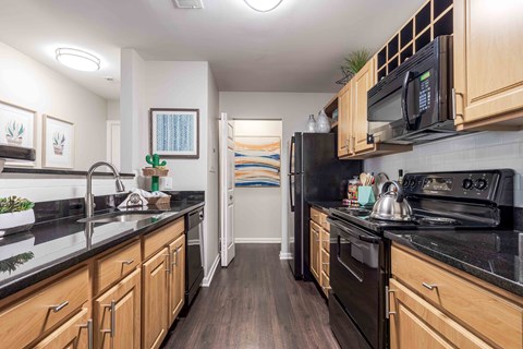 a kitchen with black appliances and wooden cabinets