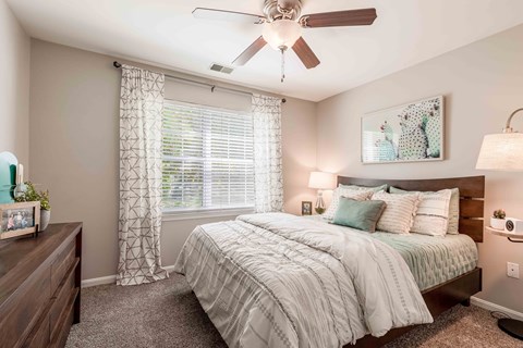 a bedroom with a bed and a ceiling fan